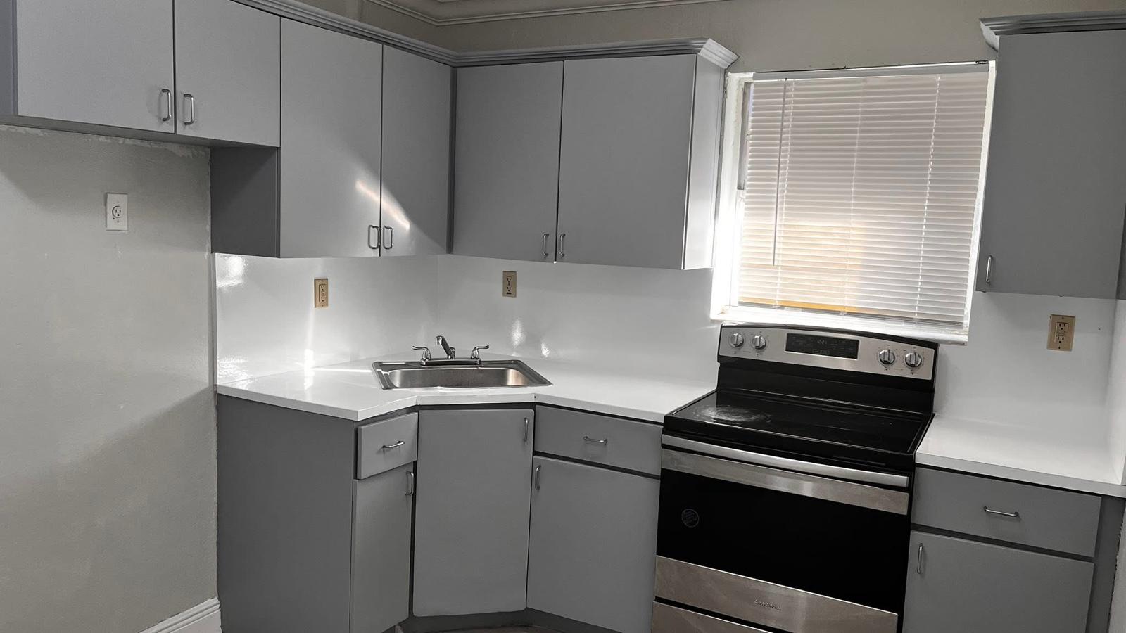 Same kitchen with cabinets refinished in modern gray