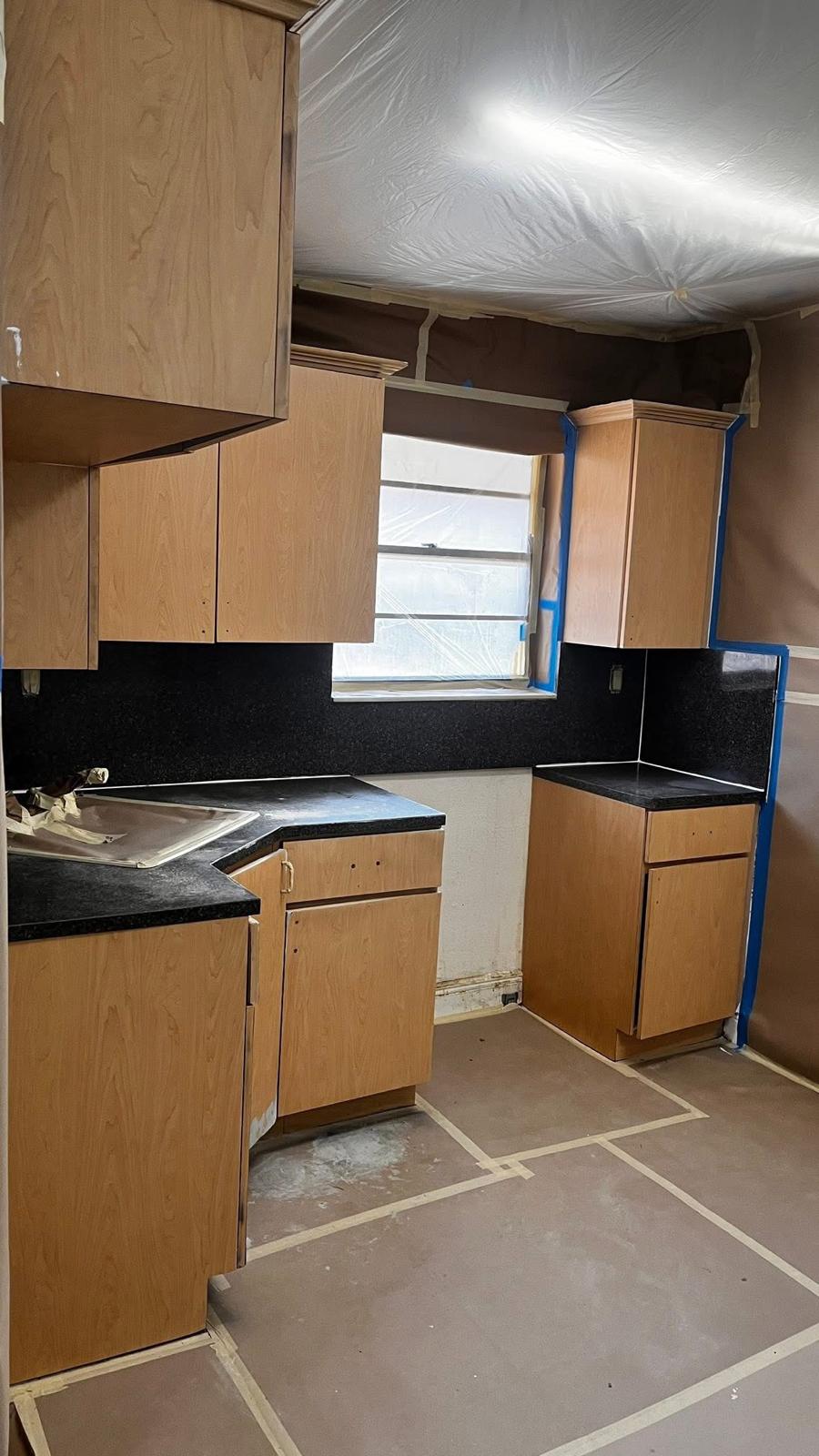 Kitchen with dated wood cabinets before painting